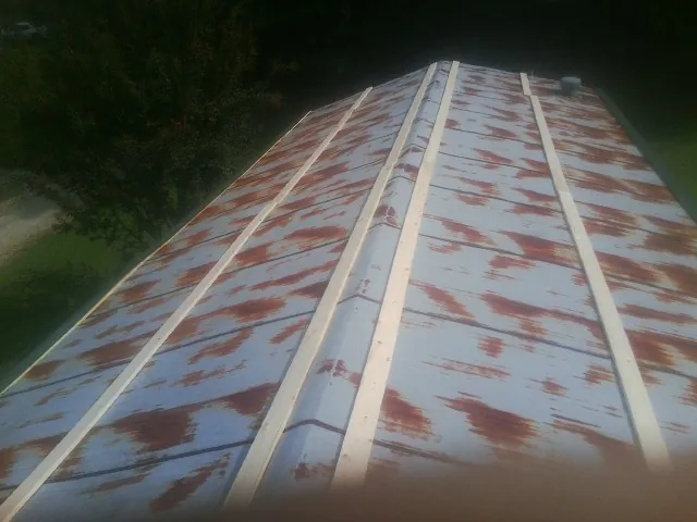 Rusted metal roof panels with new wood purlins before replacement — Storm Damage Roof Repair in Bethany Beach by Roofing Brothers
